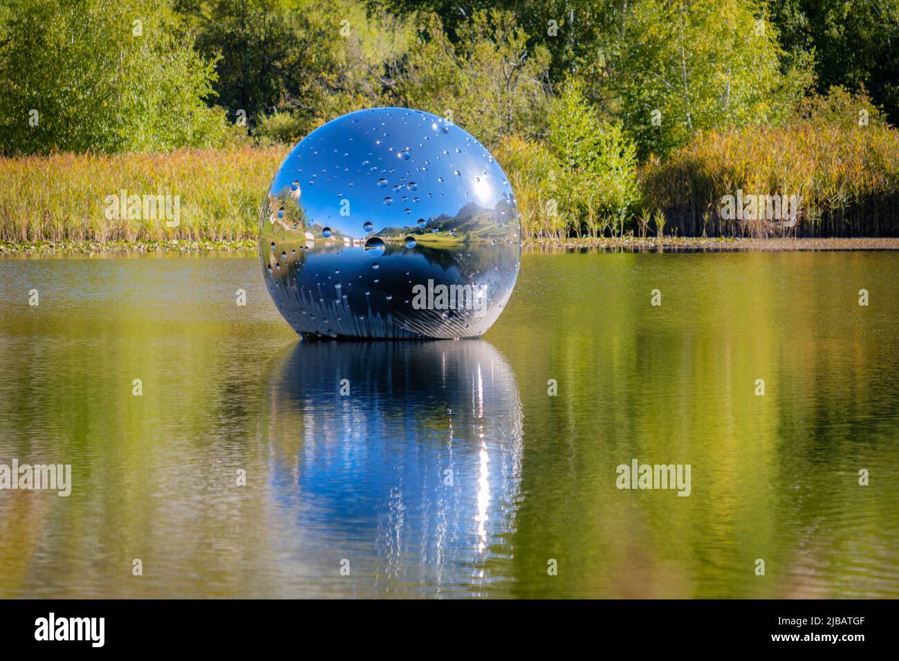 Taraspsee, Schweiz - 24. September 2022: Die schwimmende Metallkugel auf Taraspsee (Grisons, Schweiz) ist ein Kunstwerk des schweizer Künstlers nicht lebenswichtig. Stockfoto