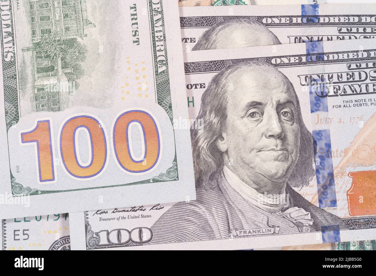 Montage Nahaufnahme des großen 100-Nummern-Designs auf der Rückseite eines USA One Hundred Dollar Bill zusammen mit einer weiteren Notiz, die Benjamin Franklin zeigt. Stockfoto