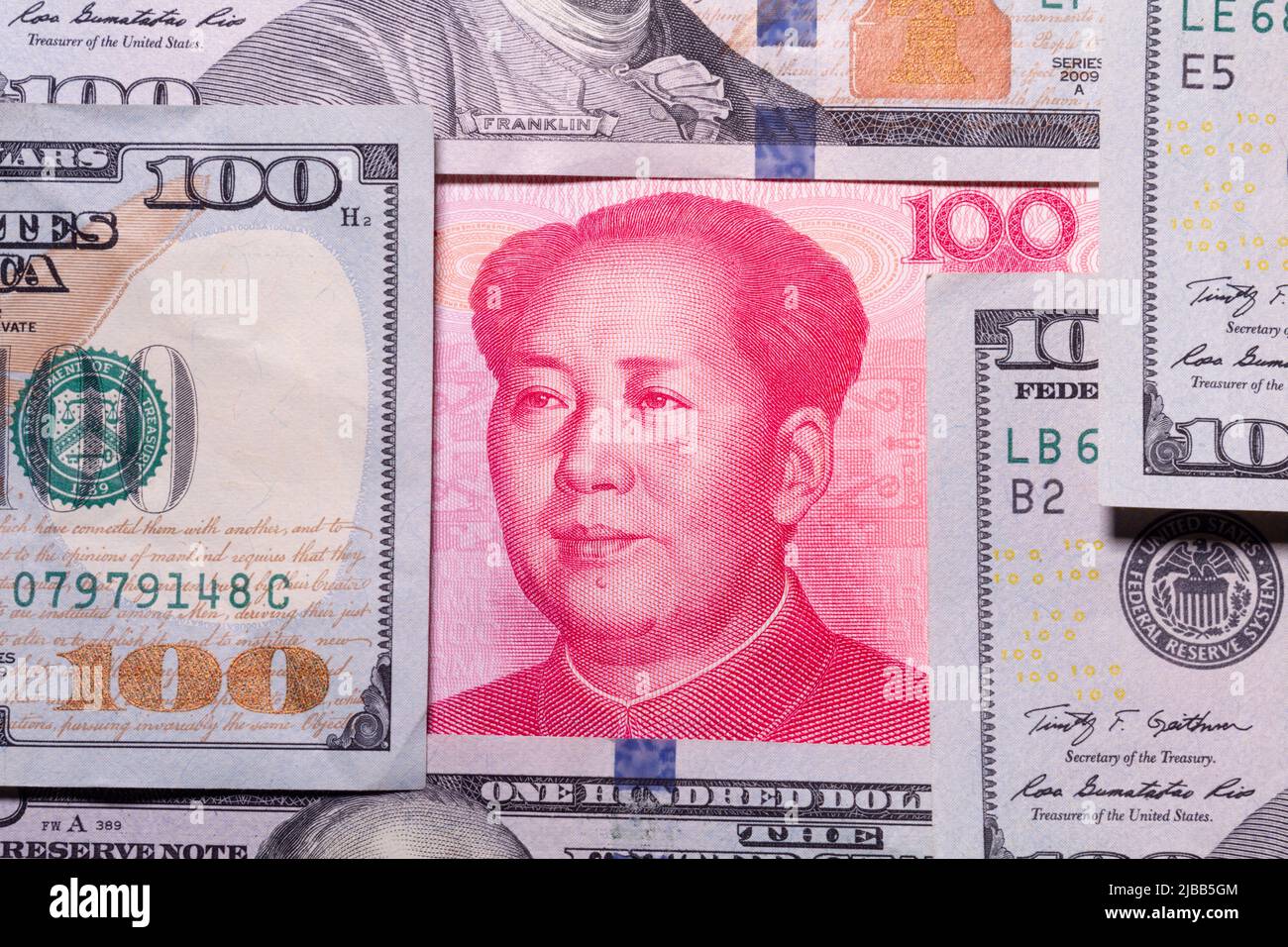 Eine einhundert RMB-Yuan-Währungsnote aus China, die in einem begrenzten Konzept von einer Anzahl von einhundert Dollar-Banknoten aus den Vereinigten Staaten zentriert wurde. Stockfoto