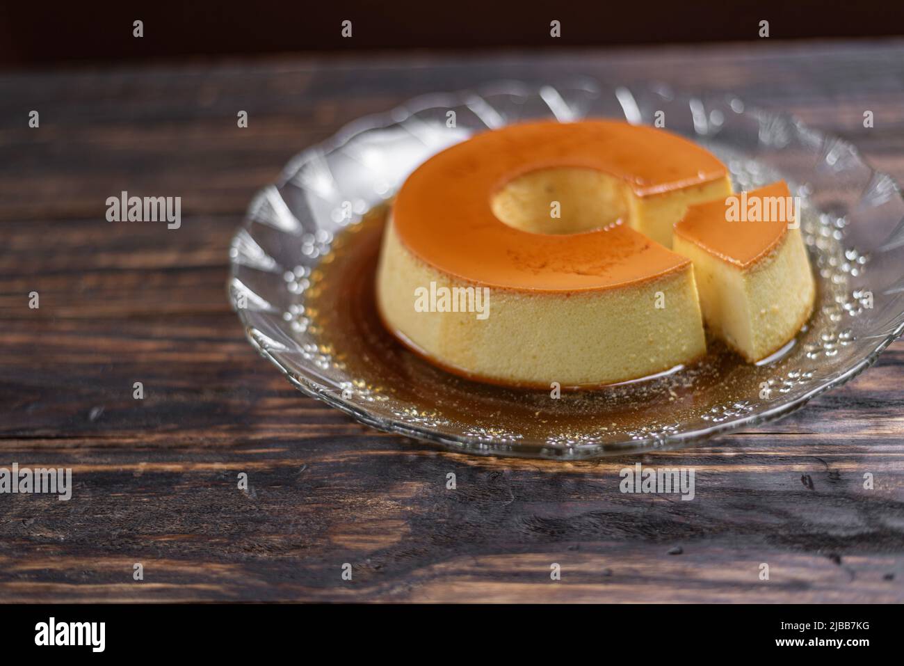 Milchpudding oder Pudim de leite. Brasilianischer Nachtisch hausgemachter Karamell-Pudding. Traditioneller brasilianischer Flan auf Holzhintergrund Stockfoto
