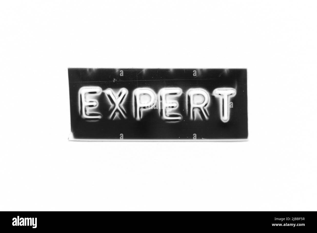 Schwarzes Farbbanner mit geprägtem Brief mit Word-Experte auf weißem Papierhintergrund Stockfoto