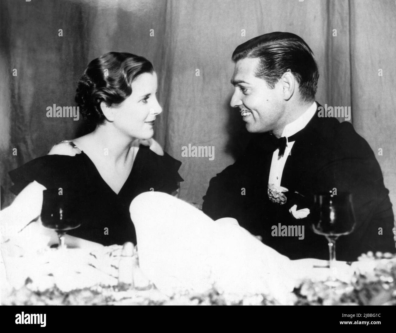 Die MGM-Filmstars DIANA WYNYARD und CLARK GABLE saßen bei der großzügigen '62.' Birthday Party für die MGM-Schauspielerin Marie Dressler, an der im November 1933 ''rund 8.000 Gäste'' teilnahmen Stockfoto