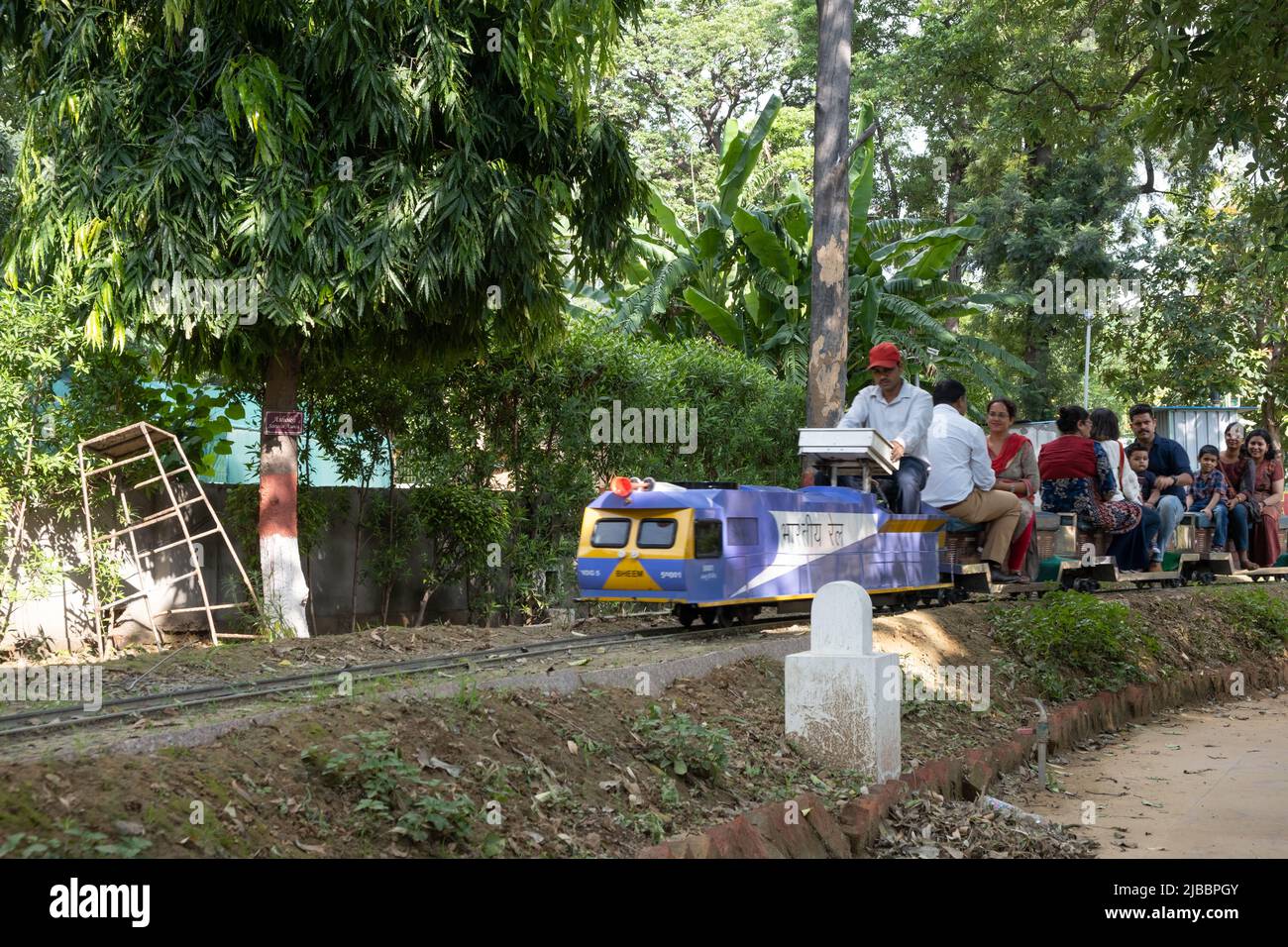 Die Fahrgäste genießen die Fahrt mit dem Spielzeugzug im National Railway Museum in Delhi. Stockfoto