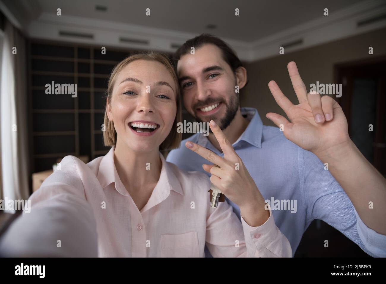 Ein Paar mit den Tasten starrte auf die Kamera und zeigte eine Siegesgeste Stockfoto