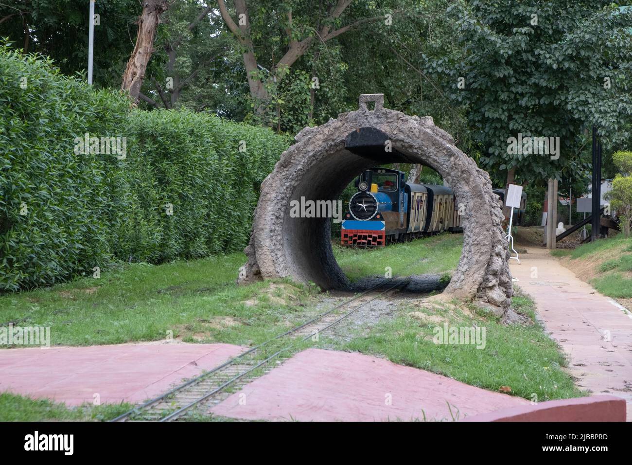 Die Fahrgäste genießen die Fahrt mit dem Spielzeugzug im National Railway Museum in Delhi. Stockfoto