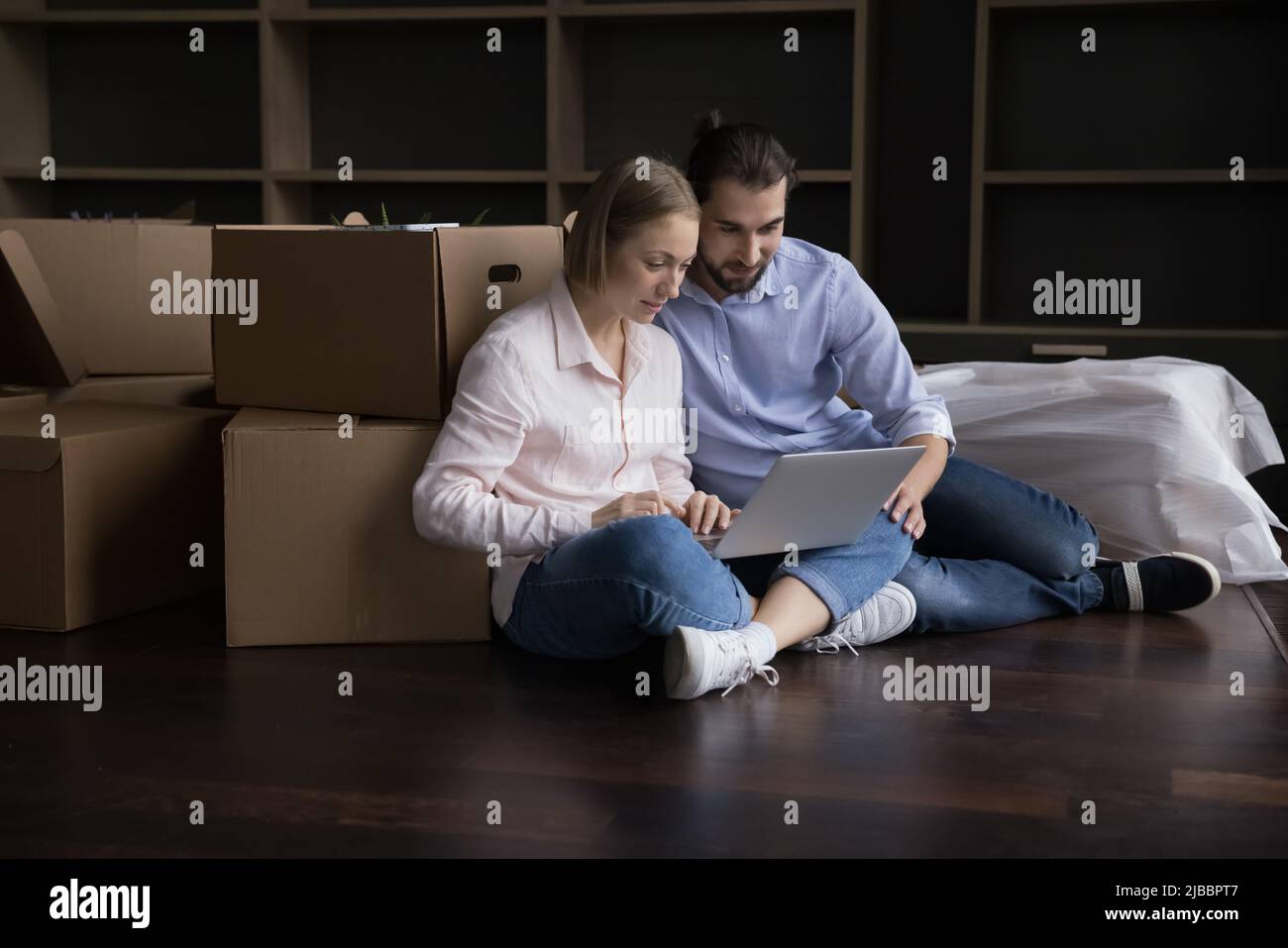 Verheiratetes Paar kauft am Umzugstag im Internet einen Laptop Stockfoto