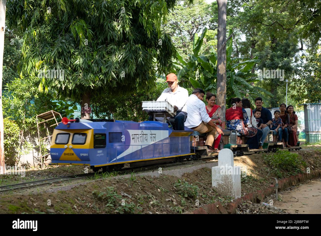 Die Fahrgäste genießen die Fahrt mit dem Spielzeugzug im National Railway Museum in Delhi. Stockfoto