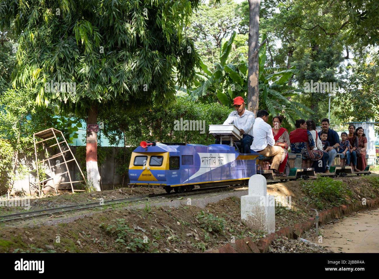 Die Fahrgäste genießen die Fahrt mit dem Spielzeugzug im National Railway Museum in Delhi. Stockfoto