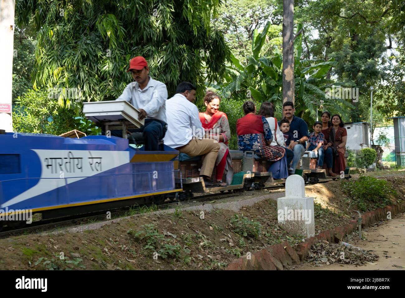Die Fahrgäste genießen die Fahrt mit dem Spielzeugzug im National Railway Museum in Delhi. Stockfoto