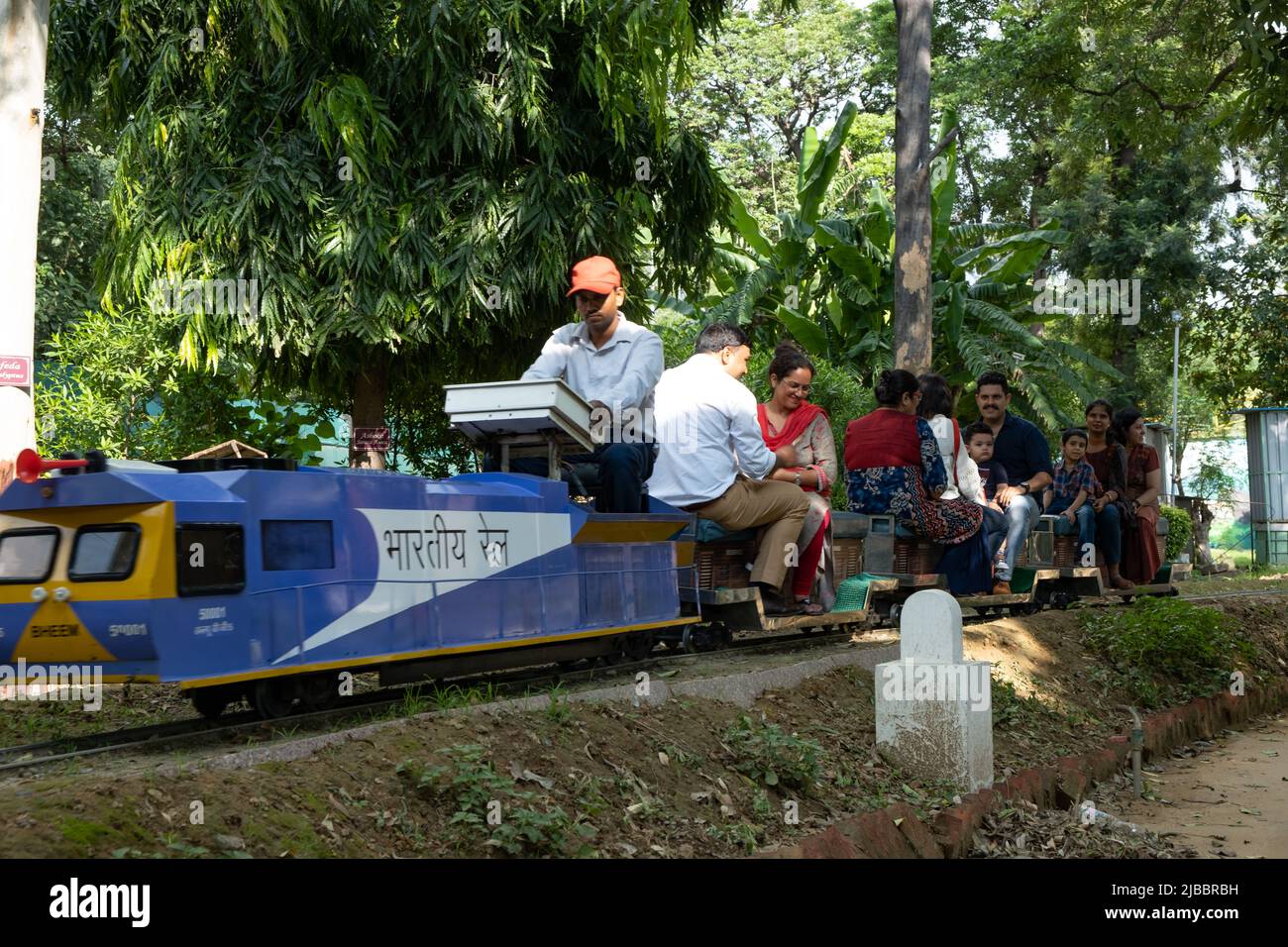 Die Fahrgäste genießen die Fahrt mit dem Spielzeugzug im National Railway Museum in Delhi. Stockfoto