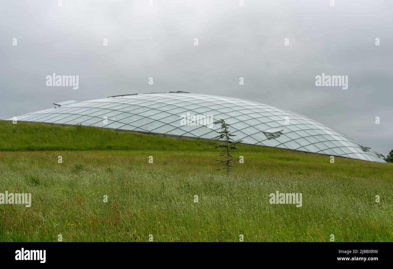 Futuristische Konservatoriumkuppel aus Glaspaneelen in Stahlträgern, die sich an einem Hang befinden. Wales Botanic Garden ist das größte einspaltige Gewächshaus der Welt Stockfoto