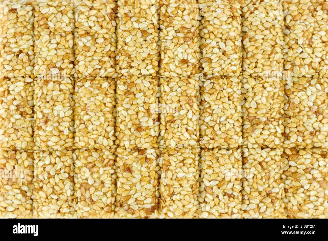 Sesamrösten in Nahaufnahme. Süßigkeiten aus Sesam. Weiß geröstete Sesamsamen in Karamell, frisches Kozinaki Stockfoto