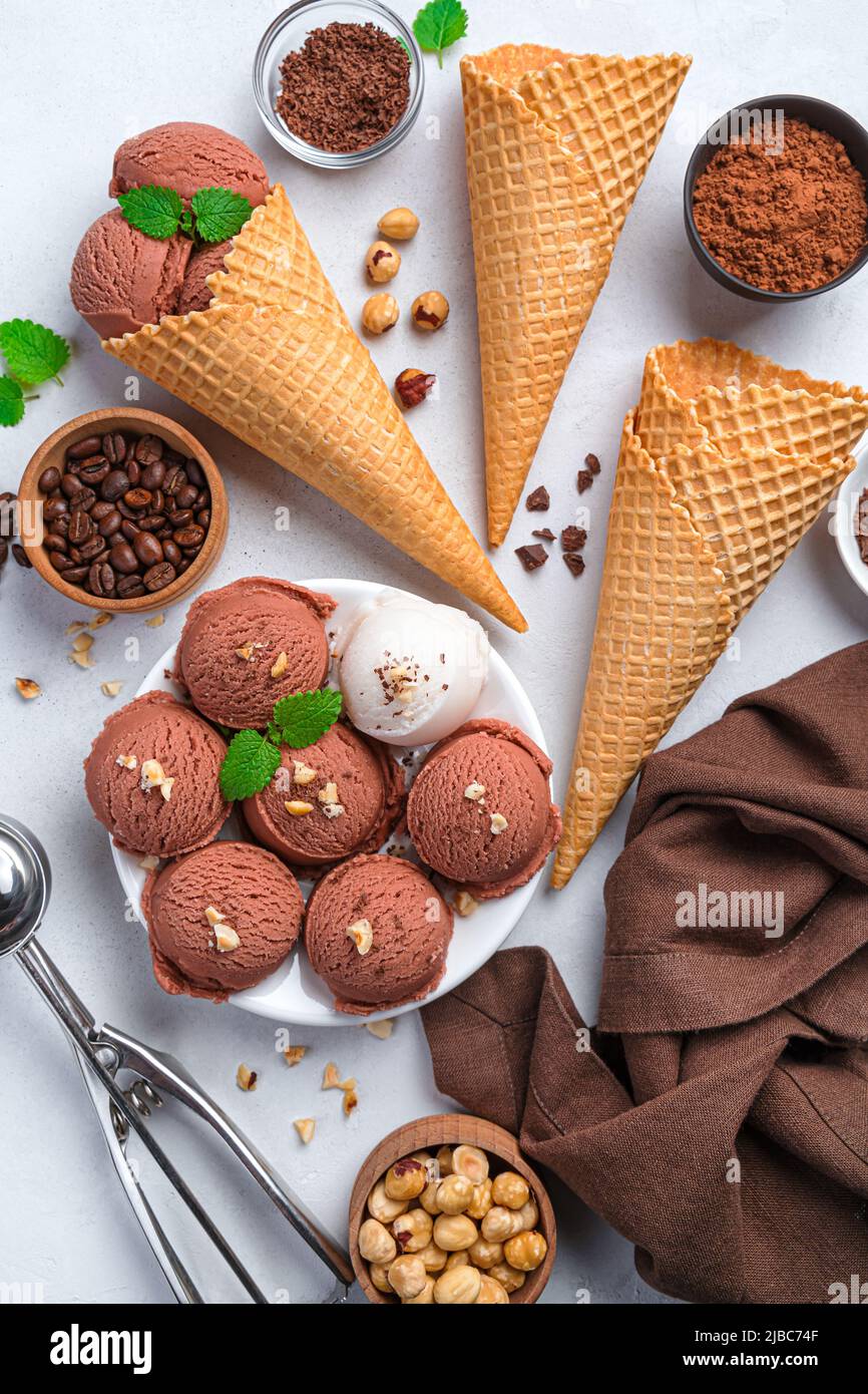 Kugeln aus Schokolade und Speiseeis auf grauem Hintergrund. Stockfoto