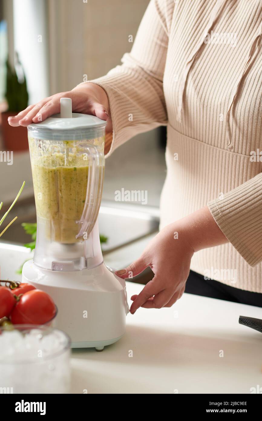 Frau, die Zutaten für einen gesunden Fruchtmoothie mischt Stockfoto