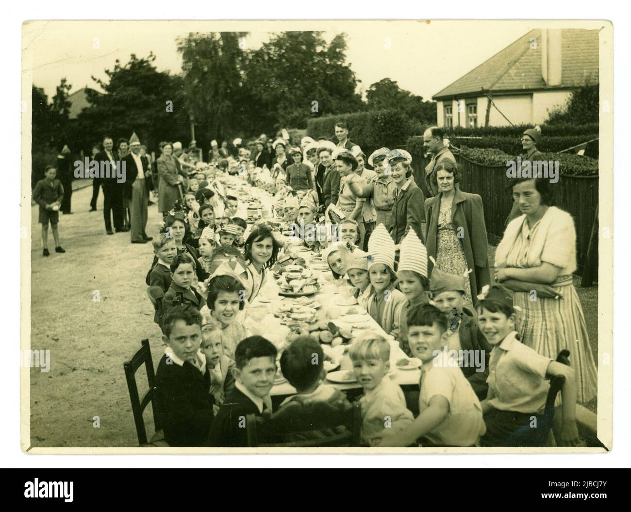 Original-Familienfoto aus dem Jahr WW2 von der Straßenparty für Kinder in einem Vorort zur Feier des Sieges über den Japan Day (V.J. Day). Danach sollte ein Lagerfeuer angezündet werden, auf dem die Bildnis von Hitler und Mussolini zu sehen war. Der 15. August ist der offizielle V-J-Tag für das Vereinigte Königreich, während der offizielle US-Gedenktag der 2. September ist. Diese Straßenparty fand 2 Tage später an einem Freitag statt, datiert vom 17. 1945. August, Großbritannien Stockfoto