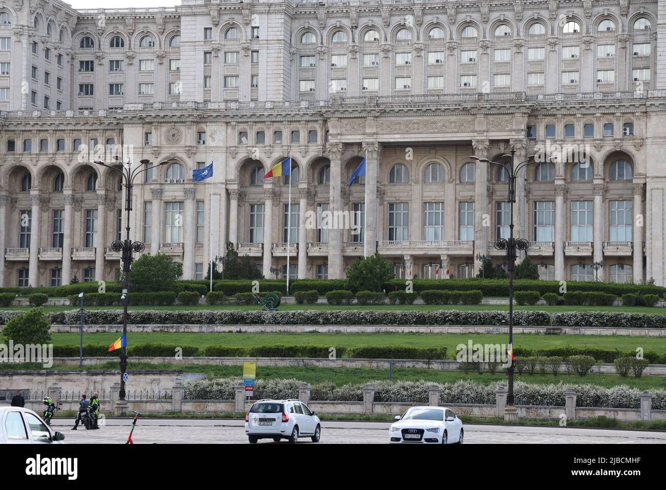 NATO-, Rumänisch- und EU-Flaggen vor dem Haus des Volkes in Bukarest, Rumänien, dem 2. größten Gebäude der Welt. Sitz des parlaments Stockfoto