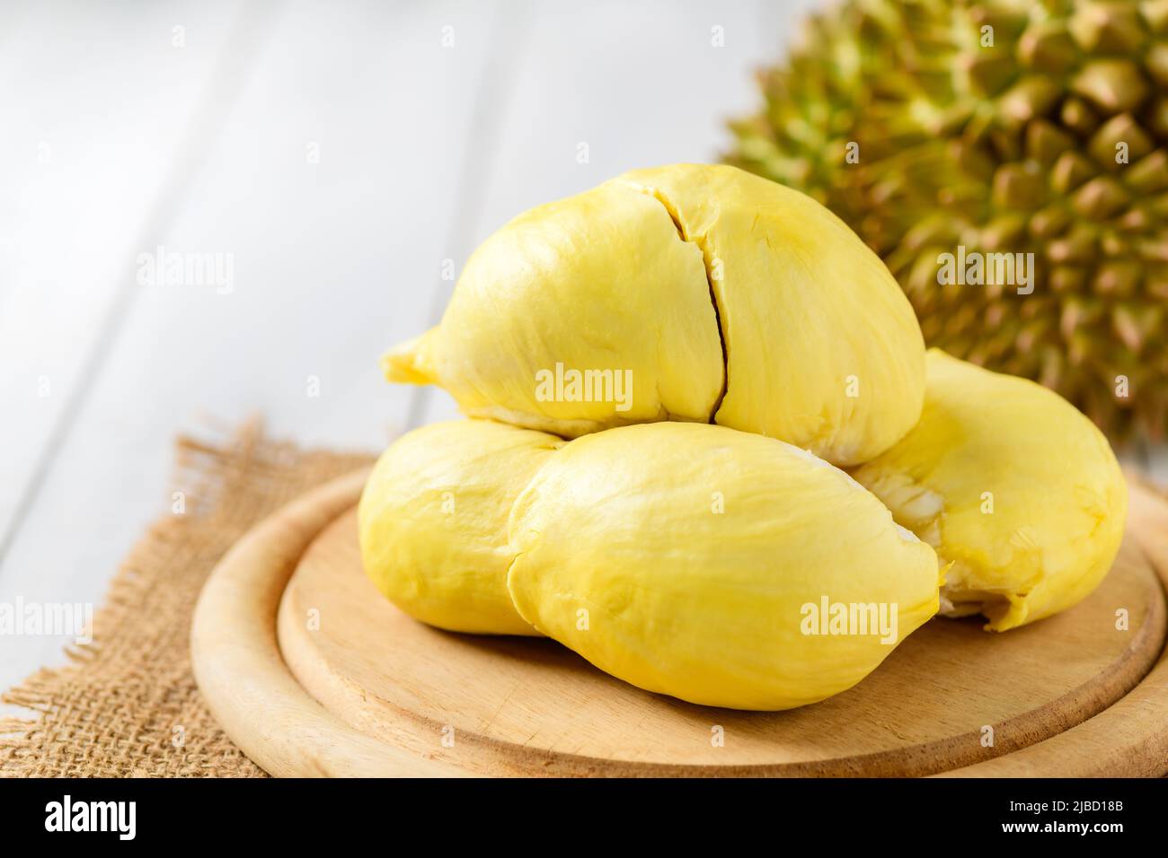 Frischer Durian (Monthong) auf Holzplatte und weißem Holzhintergrund, König der Früchte aus Thailand in der Sommersaison Stockfoto