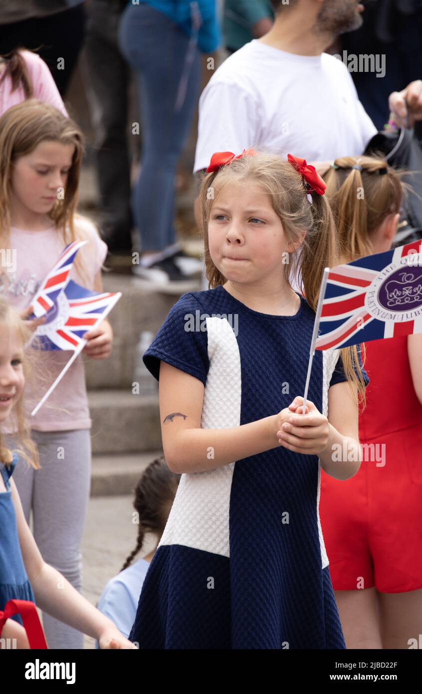 Kinder winken Gewerkschaftsflaggen zur Feier des Platin-Jubiläums der Königin, im Freien auf der Straße, Newmarket Suffolk UK Stockfoto