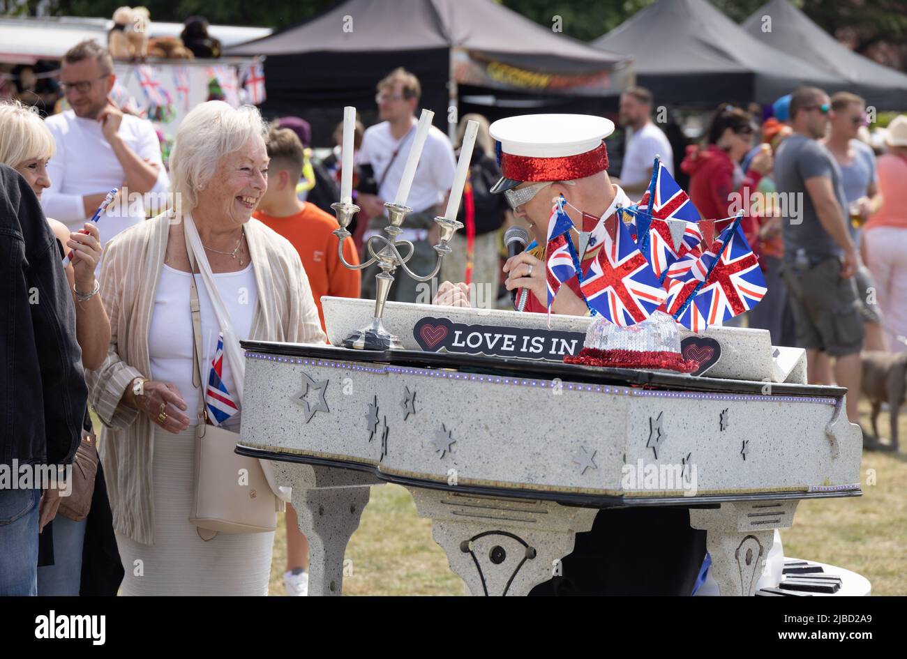 Exzentrischer englischer Lebensstil; Ein Mann, der als Elton John gekleidet ist, sieht sich ähnlich und spricht mit einer Frau auf den Platinum Jubilee Feiern, Newmarket Suffolk UK Stockfoto