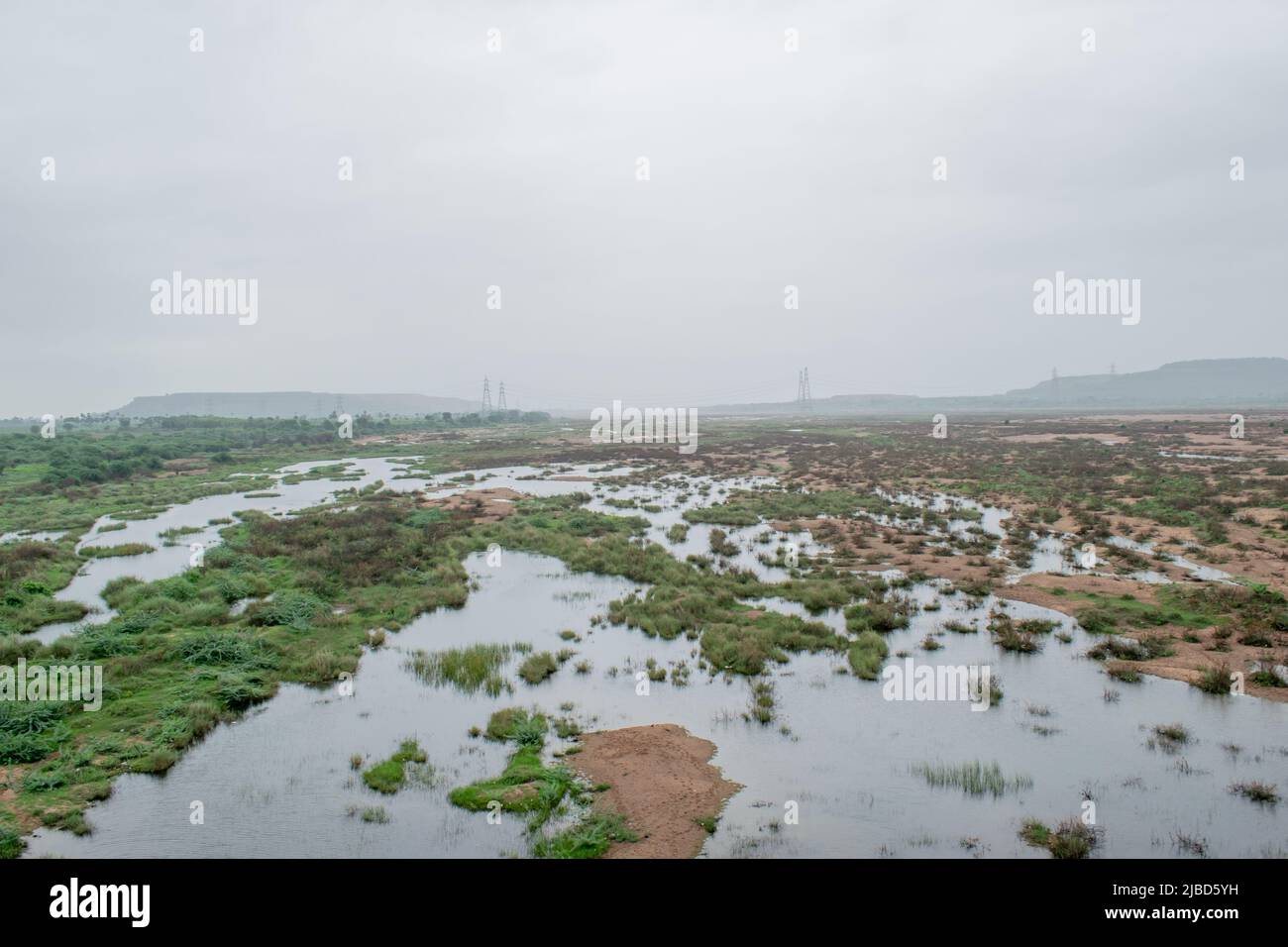 Wasser fließt durch das Land aufgrund einer kleinen Überschwemmung Stockfoto