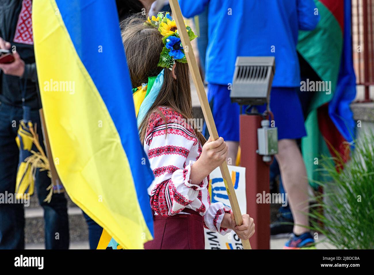 Ein junges Mädchen, das einen Vinok oder Blumenkranz trägt und eine ukrainische Flagge bei einer Kundgebung oder einem marsch für den Frieden in der Ukraine hält. Calgary, Alberta, Kanada Stockfoto