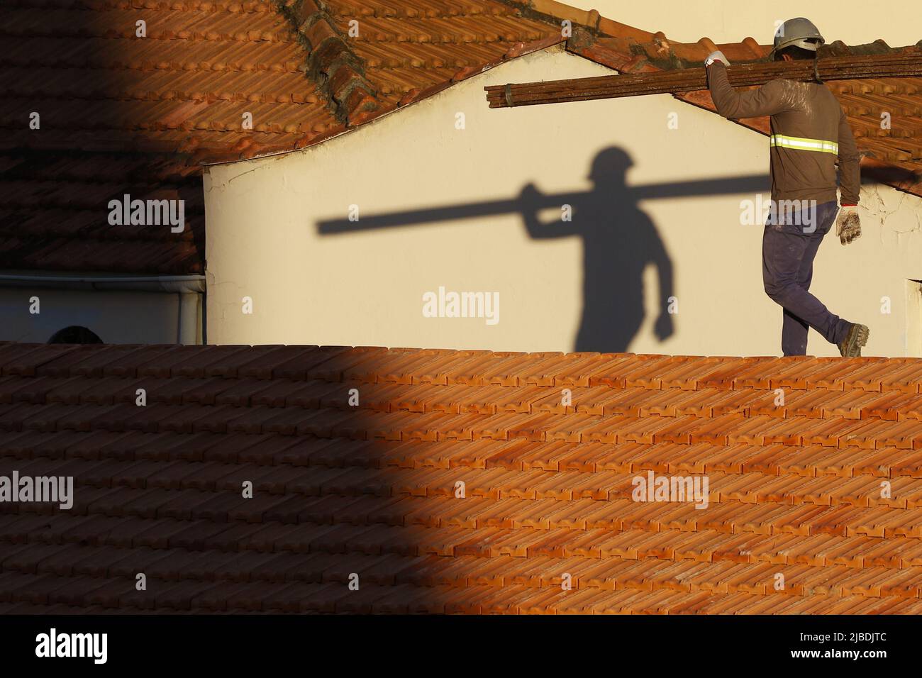 Dachdecker, der am Dachbau arbeitet. Reparatur des Ziegeldachs. Haus im Bau. Arbeiter renoviert Abdichtung Dach des Gebäudes. Zimmermann Stockfoto
