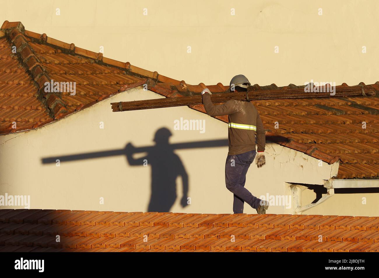 Dachdecker, der am Dachbau arbeitet. Reparatur des Ziegeldachs. Haus im Bau. Arbeiter renoviert Abdichtung Dach des Gebäudes. Zimmermann Stockfoto