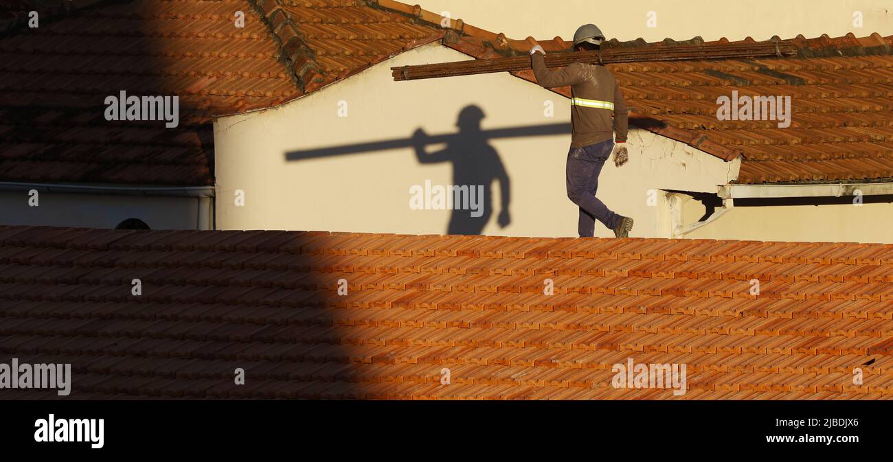 Dachdecker, der am Dachbau arbeitet. Reparatur des Ziegeldachs. Haus im Bau. Arbeiter renoviert Abdichtung Dach des Gebäudes. Zimmermann Stockfoto