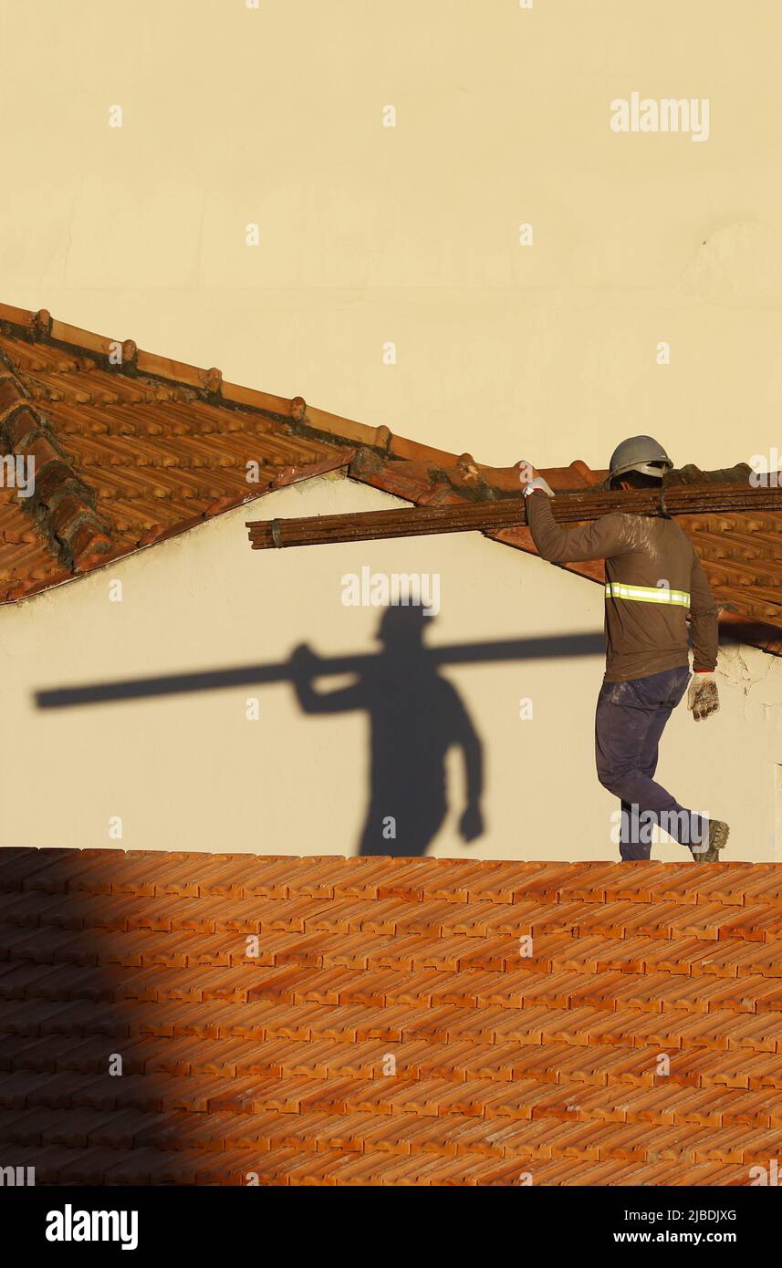 Dachdecker, der am Dachbau arbeitet. Reparatur des Ziegeldachs. Haus im Bau. Arbeiter renoviert Abdichtung Dach des Gebäudes. Zimmermann Stockfoto