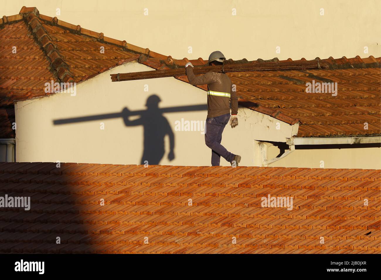 Dachdecker, der am Dachbau arbeitet. Reparatur des Ziegeldachs. Haus im Bau. Arbeiter renoviert Abdichtung Dach des Gebäudes. Zimmermann Stockfoto