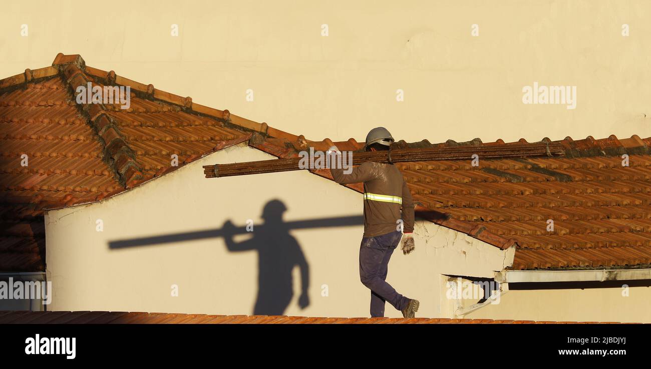 Dachdecker, der am Dachbau arbeitet. Reparatur des Ziegeldachs. Haus im Bau. Arbeiter renoviert Abdichtung Dach des Gebäudes. Zimmermann Stockfoto