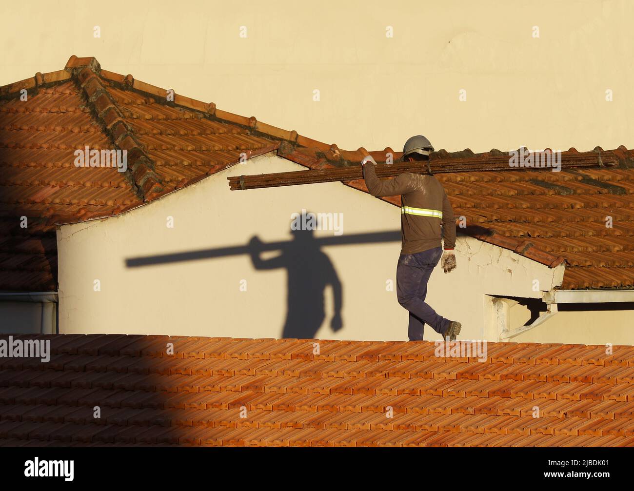 Dachdecker, der am Dachbau arbeitet. Reparatur des Ziegeldachs. Haus im Bau. Arbeiter renoviert Abdichtung Dach des Gebäudes. Zimmermann Stockfoto