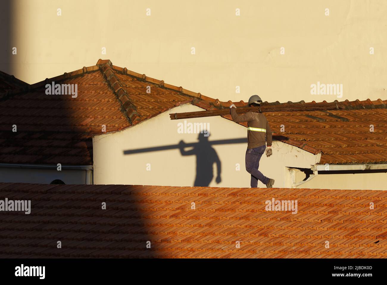 Dachdecker, der am Dachbau arbeitet. Reparatur des Ziegeldachs. Haus im Bau. Arbeiter renoviert Abdichtung Dach des Gebäudes. Zimmermann Stockfoto