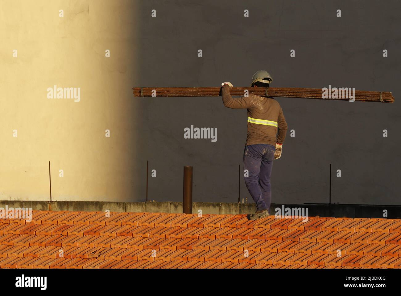 Dachdecker, der am Dachbau arbeitet. Reparatur des Ziegeldachs. Haus im Bau. Arbeiter renoviert Abdichtung Dach des Gebäudes. Zimmermann Stockfoto
