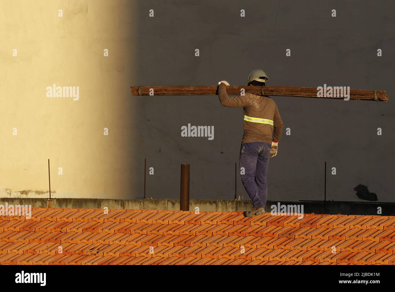 Dachdecker, der am Dachbau arbeitet. Reparatur des Ziegeldachs. Haus im Bau. Arbeiter renoviert Abdichtung Dach des Gebäudes. Zimmermann Stockfoto