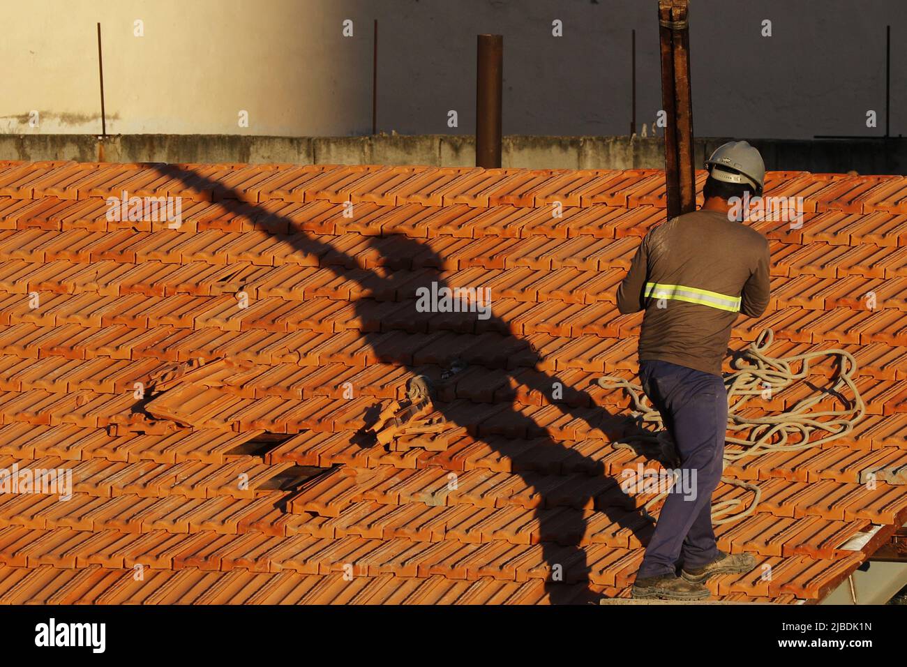 Dachdecker, der am Dachbau arbeitet. Reparatur des Ziegeldachs. Haus im Bau. Arbeiter renoviert Abdichtung Dach des Gebäudes. Zimmermann Stockfoto