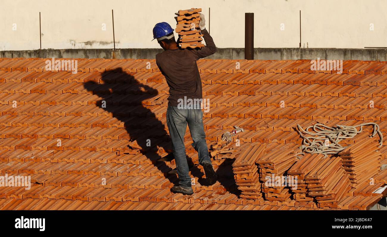 Dachdecker, der am Dachbau arbeitet. Reparatur des Ziegeldachs. Haus im Bau. Arbeiter renoviert Abdichtung Dach des Gebäudes. Zimmermann Stockfoto