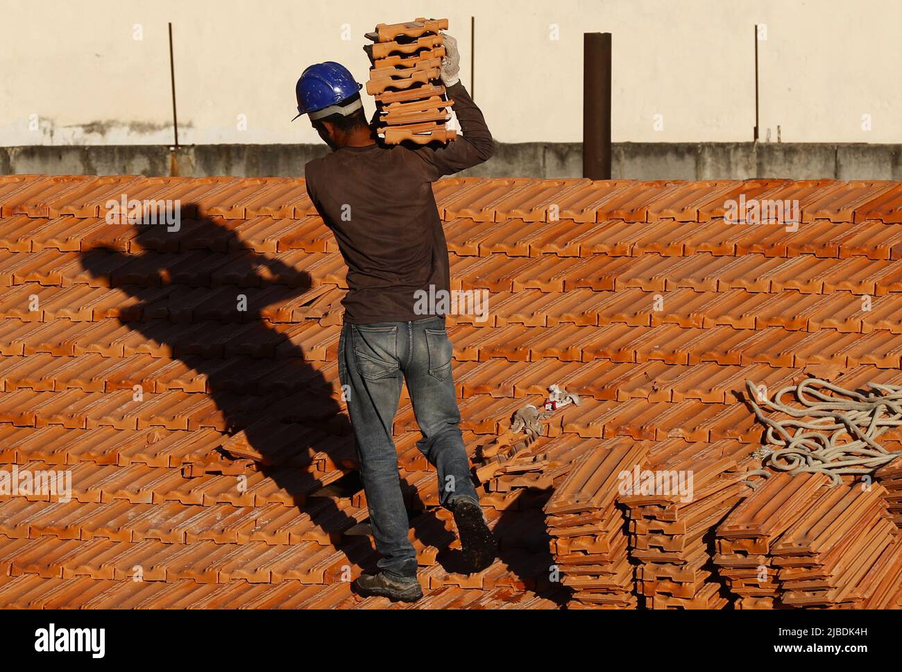 Dachdecker, der am Dachbau arbeitet. Reparatur des Ziegeldachs. Haus im Bau. Arbeiter renoviert Abdichtung Dach des Gebäudes. Zimmermann Stockfoto