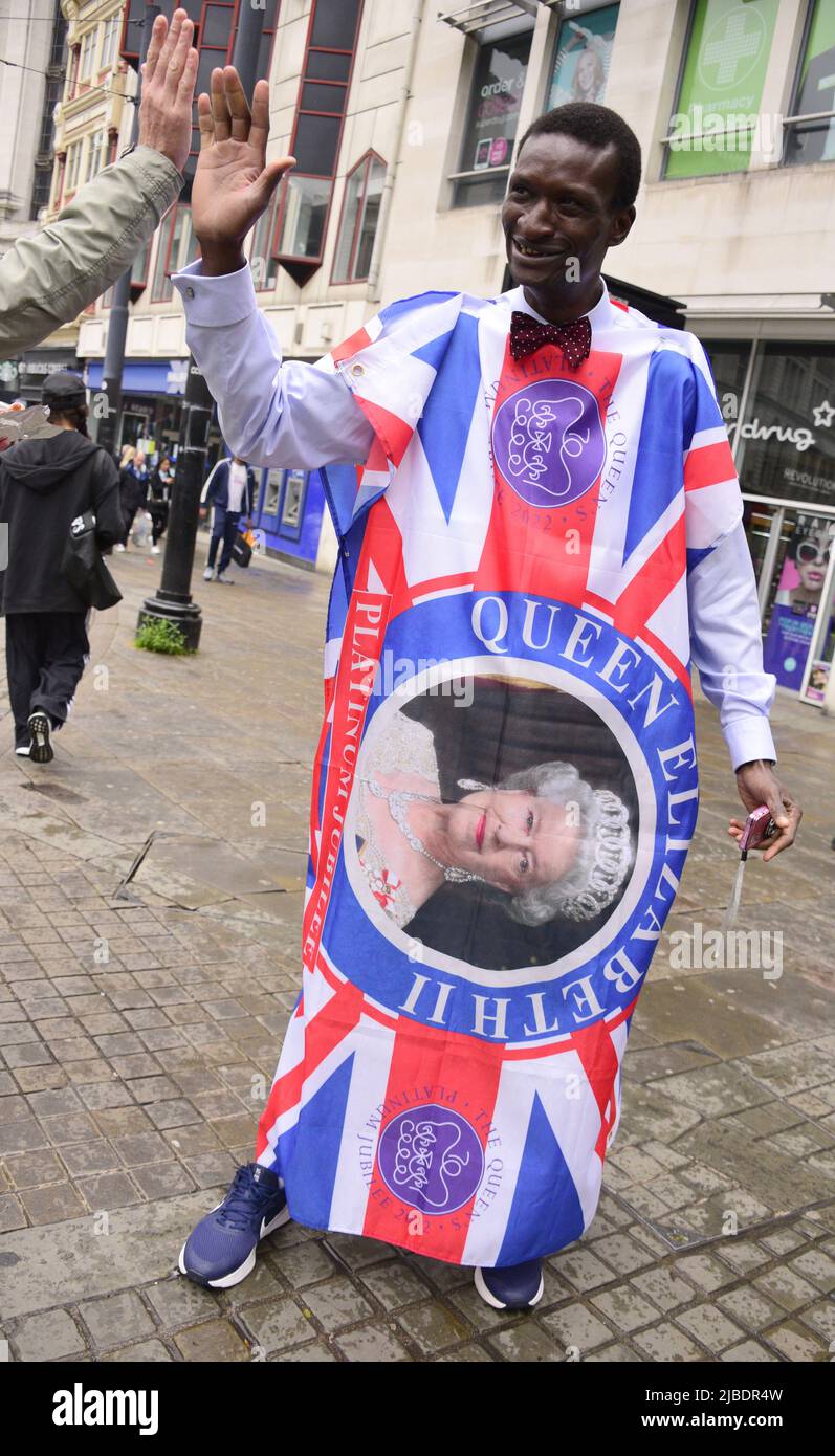 Manchester, Großbritannien. 5. Juni 2022. Ein Mann in einem Jubiläumskostüm tauscht ein High Five mit einem Passer in der Mitte von Manchester, Großbritannien, aus. Die Menschen genießen den letzten Tag des Jubilee Bank Holiday Weekend, jeder auf seine Art, in Manchester, Großbritannien. Kredit: Terry Waller/Alamy Live News Stockfoto