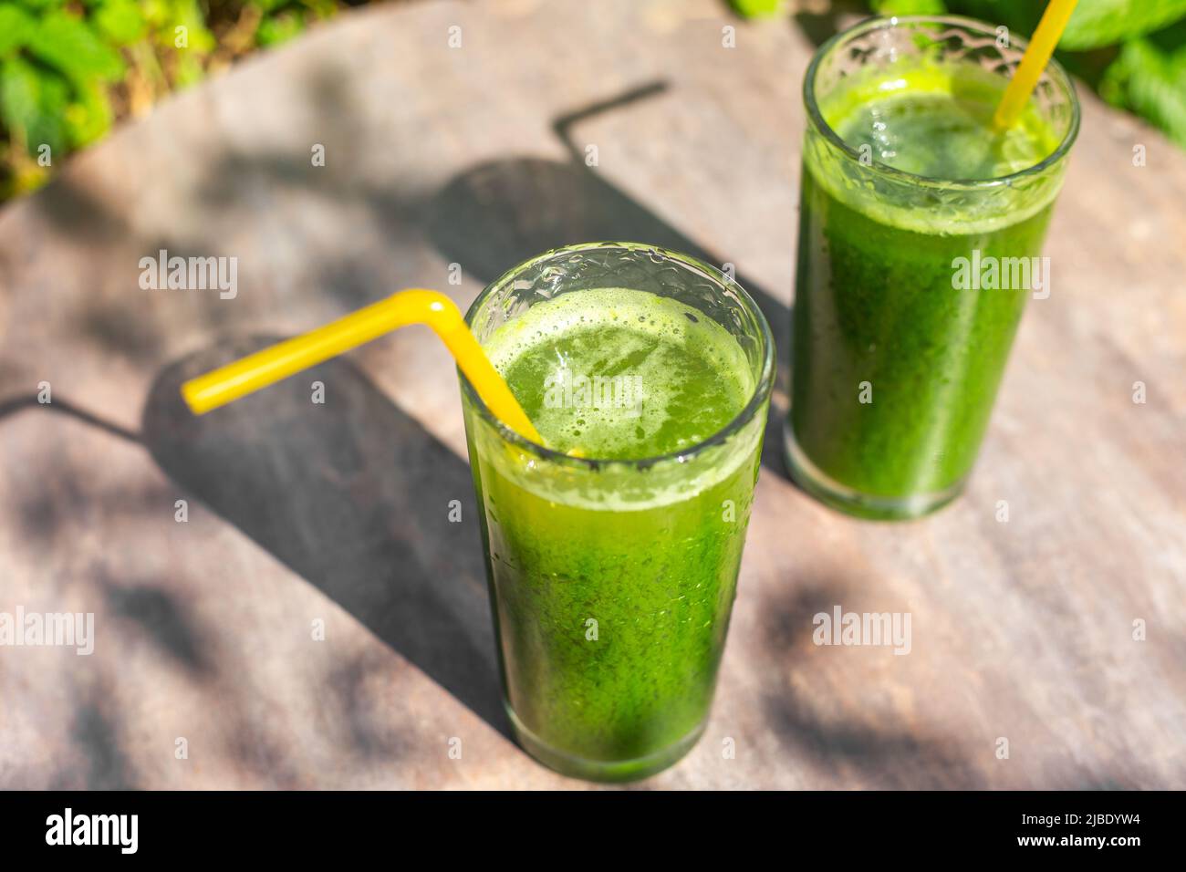 Getränke aus frischem Gemüse, Smoothies aus grünen, mit Chlorophyll gesättigten Blättern auf einem Tisch im Garten. Gesunde Ernährung. Stockfoto