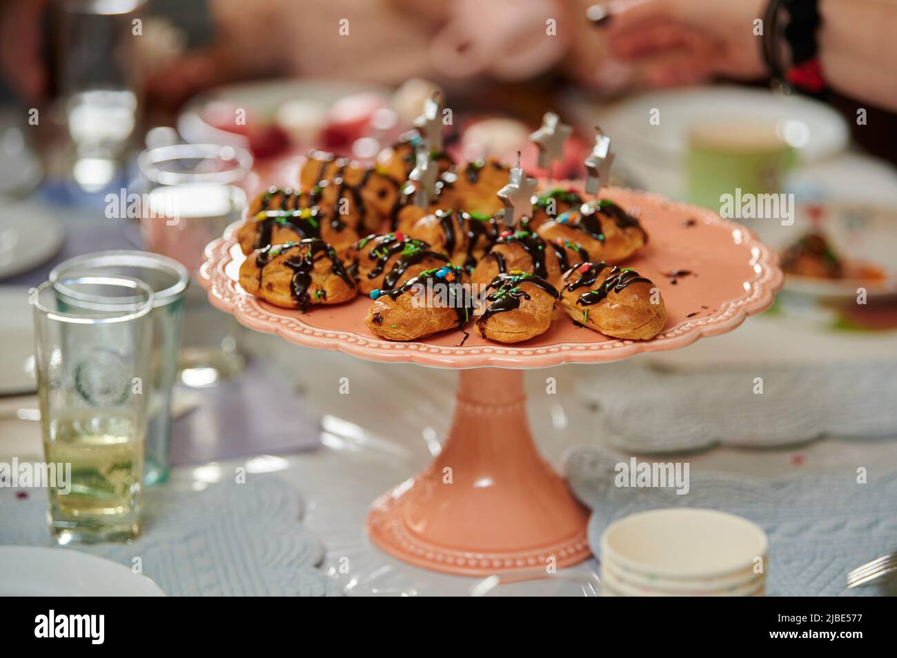 Puddingkuchen mit Schokoladenfondant auf einem Tablett auf einem festlichen Tisch mit Leckereien und Getränken Stockfoto