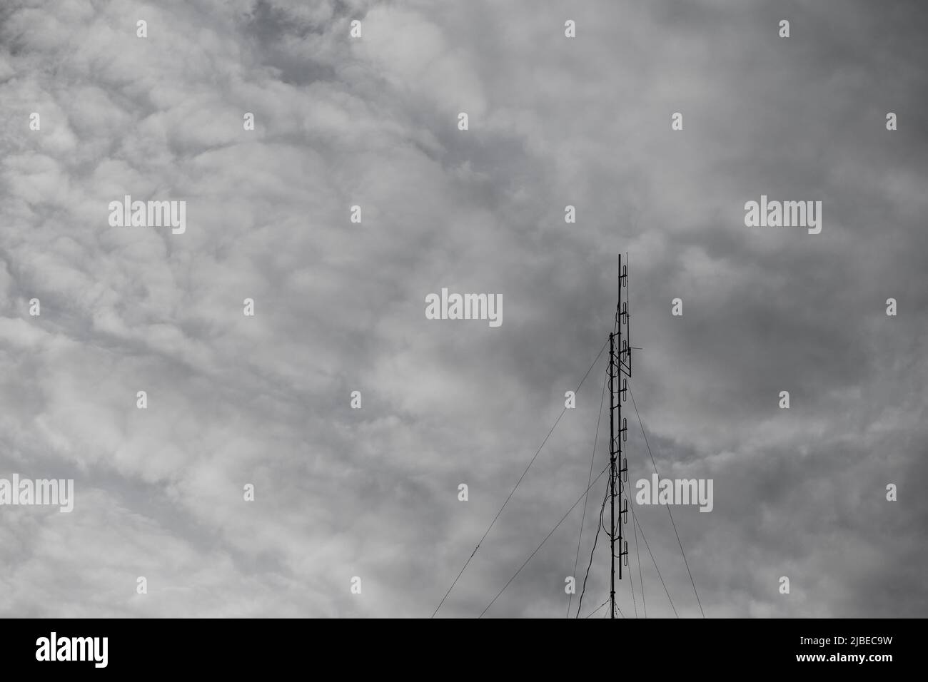 Alter Fernsehsignalempfänger.einzelne Antenne, grauer Himmel, Wettervariabilität. Stockfoto