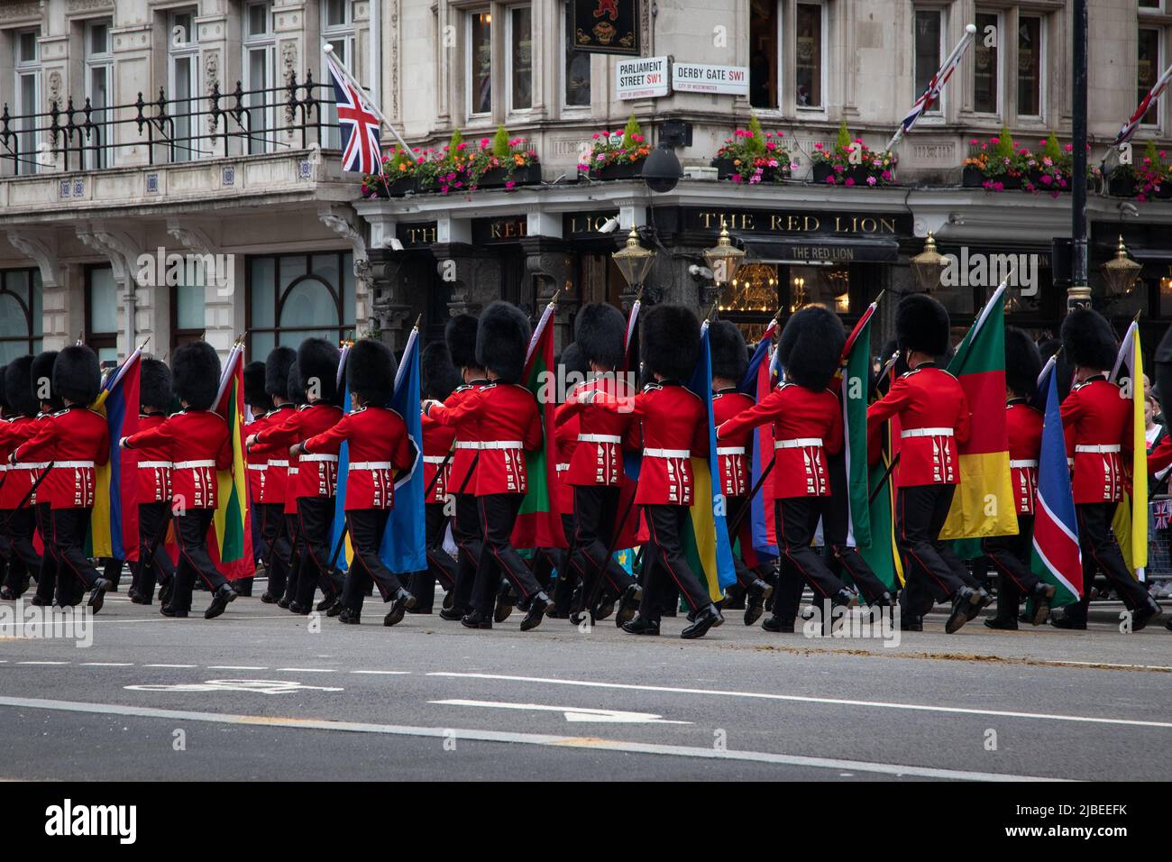 London, Großbritannien. 5.. Juni 2022. Soldaten, die die Commonwealth-Flaggen tragen, passieren den Red Lion Pub, während der Platinum Jubilee Pageant im Zentrum von London stattfindet, um die 70 Jahre auf dem Thron Ihrer Majestät zu feiern. Die Parade von 3km wird von dem goldenen Staatswagen geführt, einem 260 Jahre alten Wagen, der die Königin zu und von ihrer Krönung im Jahr 1953 trug. Quelle: Kiki Streitberger / Alamy Live News Stockfoto