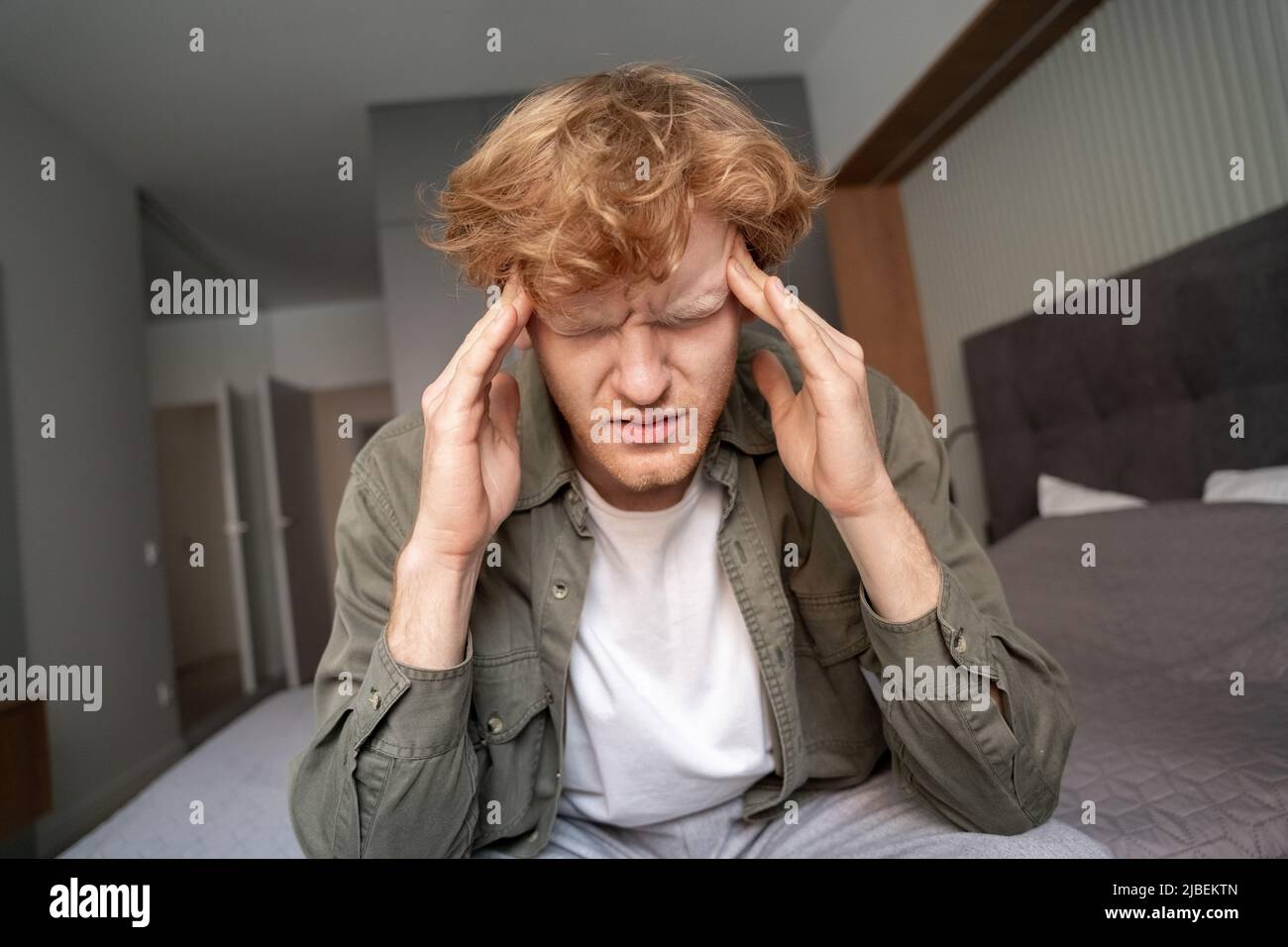 Junger Ingwer, der unter schrecklichen Kopfschmerzen oder Migräne leidet, wurde in Nahaufnahme aufgenommen Stockfoto