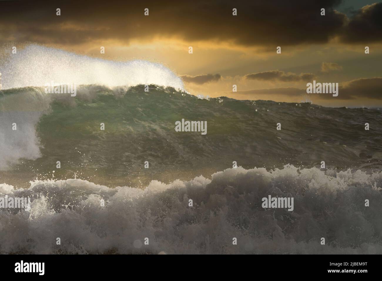 Energiereiche stürmische Wellen bei Sonnenuntergang auf Maui. Stockfoto