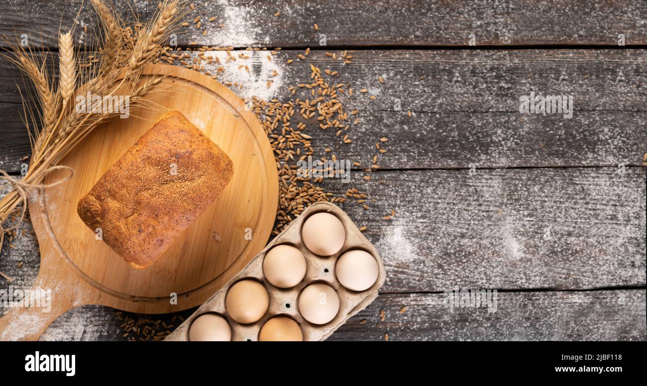 Frisch gebackenes traditionelles Weizenbrot auf Holzhintergrund, flaches Lay Stockfoto