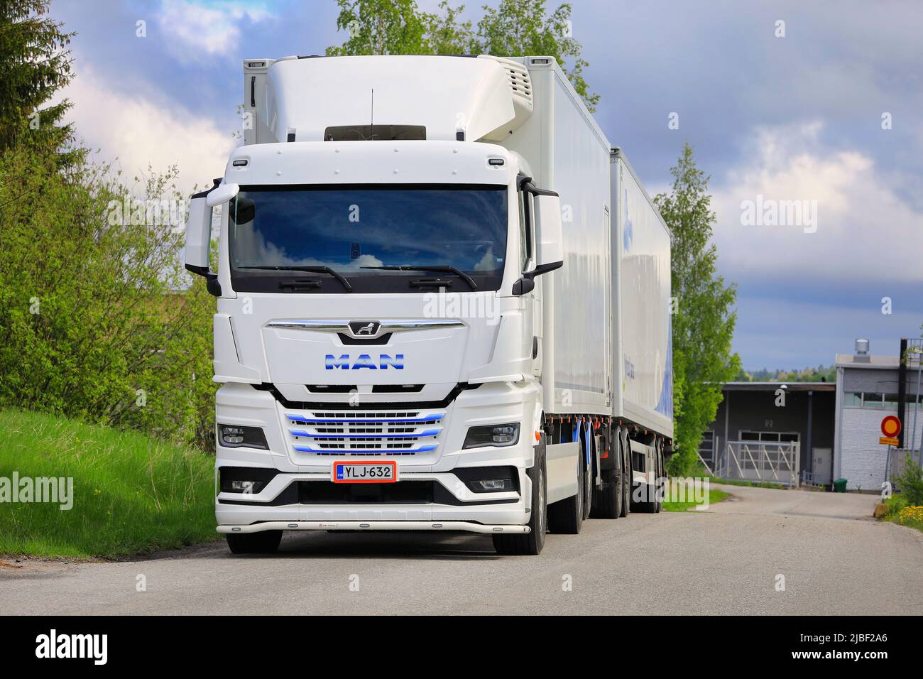 Weißer, neuer MAN TGX 26,510 LKW vor dem gekühlten Anhänger, der auf dem Asphalthof abgestellt ist. Salo, Finnland. 29.Mai 2022. Stockfoto
