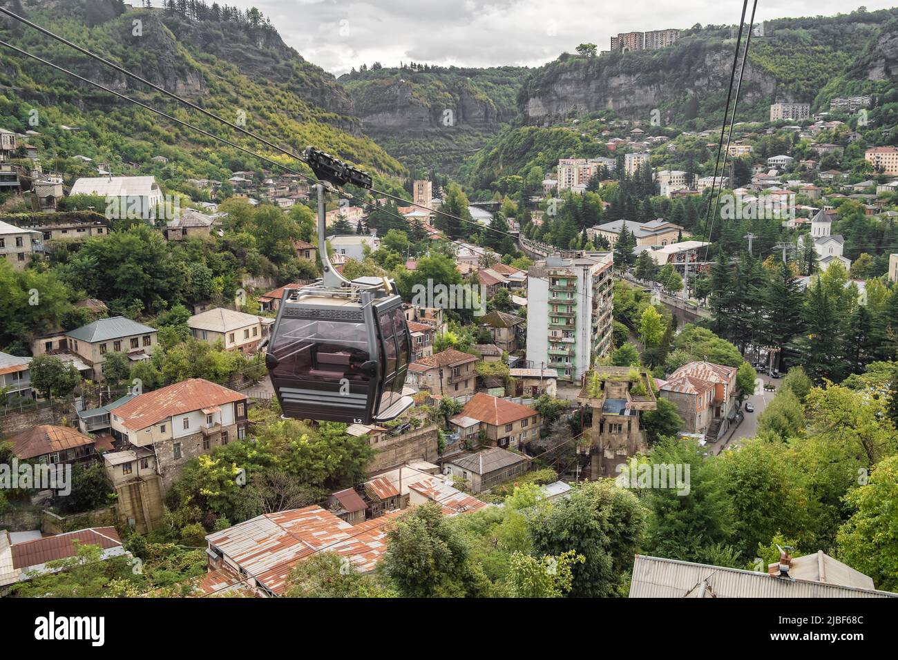 Seilbahn, die an alten gebäuden aus der sowjetzeit in der Bergarbeiterstadt Chiatura in Georgien vorbeifährt Stockfoto