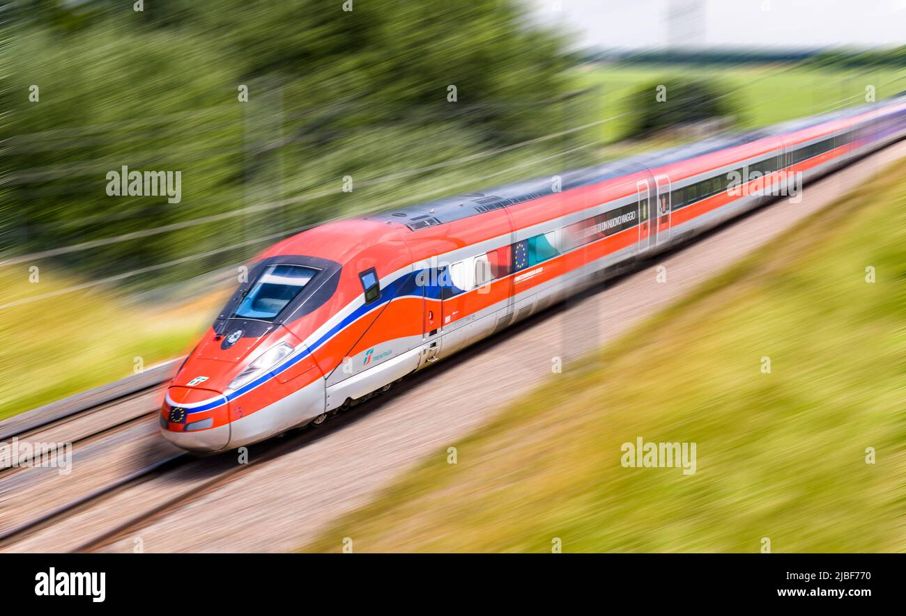 Ein Frecciarossa (ETR 1000) Hochgeschwindigkeitszug des italienischen Eisenbahnunternehmens Trenitalia fährt mit voller Geschwindigkeit auf dem Land. Stockfoto