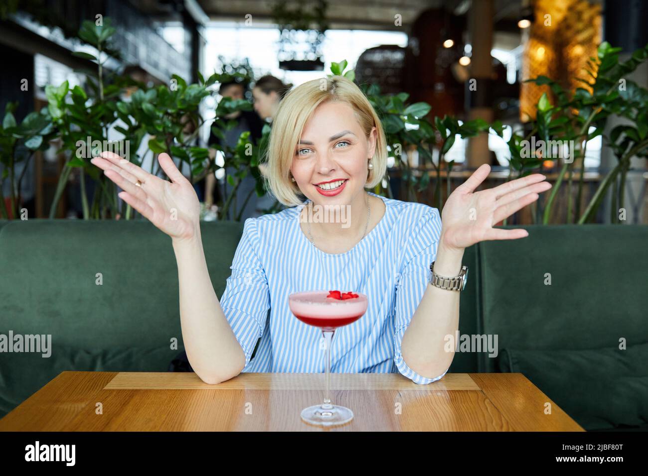 Porträt einer attraktiven jungen Frau, die einen Cocktail in einem Café trinkt Stockfoto